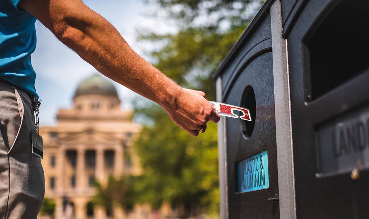 a photo of a man's hand throwing away a hang tag